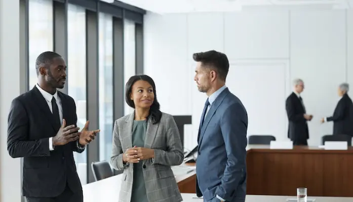 Three people in suits discussing