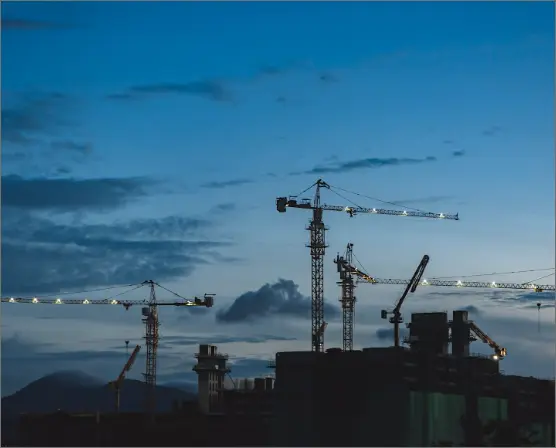 View of construction cranes with the sky in the background